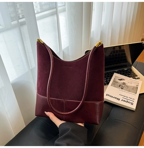 Détail du sac cabas en daim bordeaux avec fermoir doré et coutures en cuir lisse