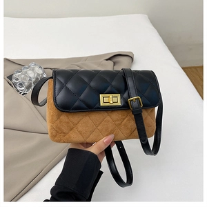 Detail of quilted leather crossbody bag with bicolor design and gold metal clasp