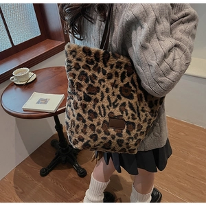 Sac cabas chic en peluche imprimé léopard porté par un mannequin dans un café