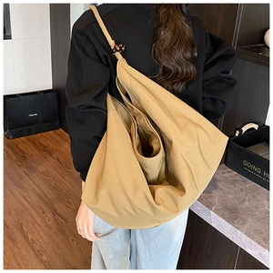 Détail du sac fourre-tout en toile kaki avec grande capacité et perle en bois sur la bandoulière