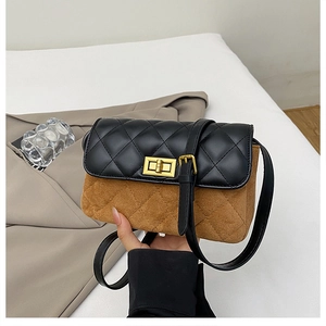 Close-up of quilted pattern stitching and gold square metal twist lock on the crossbody bag