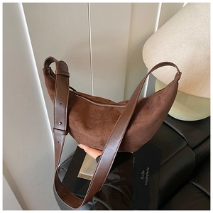 Detail of the brown suede hobo bag showing the smooth leather strap and zipper texture