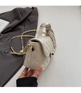 Vue détaillée d'un sac à main beige matelassé avec ferrures dorées et poignée en foulard