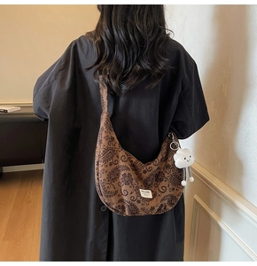 Detail der Retro-Paisley-Tasche mit breitem Gurt und weißem Plüsch-Wolkenanhänger