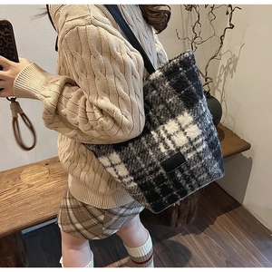 Mannequin portant un grand sac cabas en peluche à carreaux noirs et blancs chic