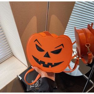 Detailed side view of orange pumpkin crossbody bag with black embroidered face