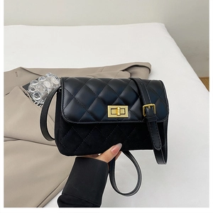 Detail view of black quilted crossbody bag with gold rectangular clasp and suede texture