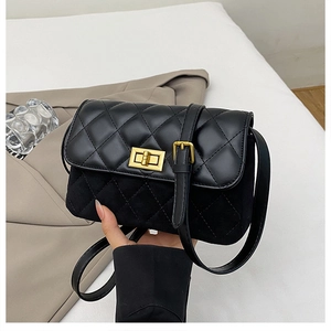 Detail view of black quilted crossbody bag showing faux leather and suede material contrast