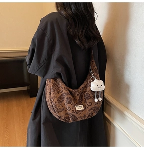 Braune Vintage-Tasche mit Paisleymuster und süßem weißen Plüsch-Wolkenanhänger am Gurt