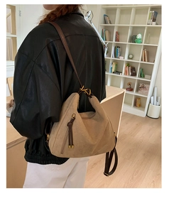 Detail of khaki frosted suede shoulder bag with brown leather strap and gold ring