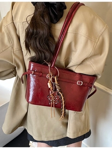Retro deep red patent leather hobo bag with leopard star charm on model shoulder