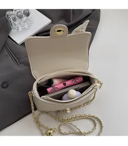 Détail des compartiments internes spacieux d'un sac à bandoulière matelassé beige