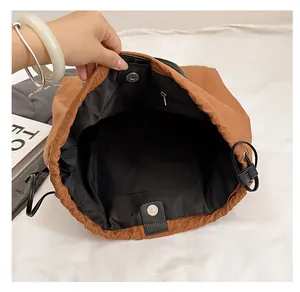 Detailed interior of the brown drawstring bucket bag featuring secure magnetic closure and pockets