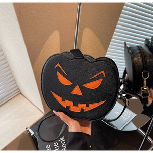 Detail of pumpkin-shaped crossbody bag with orange face and black pebbled PU leather