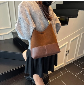 Détail du sac Hobo marron foncé en patchwork de daim et cuir avec boucles dorées