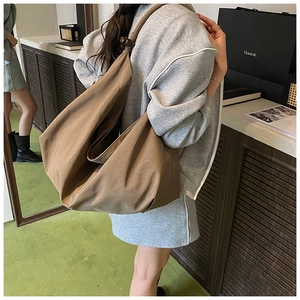 Détail du grand sac hobo en toile marron avec perles en bois sur la bandoulière