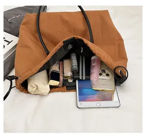 Internal view of large brown nylon tote bag showing high capacity for daily essentials