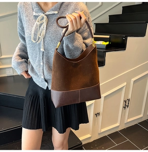 Gros plan du sac en daim marron et cuir lisse avec des ferrures dorées élégantes