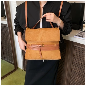 Detalle de bolso bandolera vintage caramelo mate con solapa y hebilla dorada fina