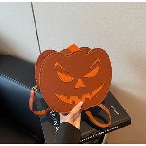 Detail of the pumpkin shoulder bag showing orange PU leather texture and facial appliqué