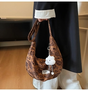 Detail der Vintage-Paisley-Segeltuchtasche mit Plüschwolken-Anhänger und Webetikett