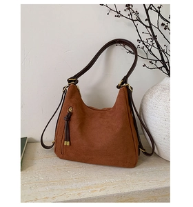 Detail of brown faux suede hobo bag with tassel zipper and vintage gold hardware