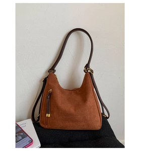Detail of vintage brown frosted leather tote bag with vertical zipper and tassel detail
