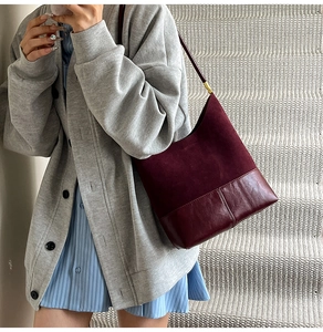 Detail view of burgundy tote bag with split suede and leather texture on model