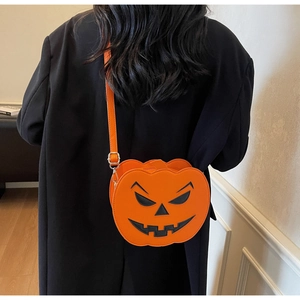 Detail view of pumpkin crossbody bag with leather texture and Jack-o'-lantern face