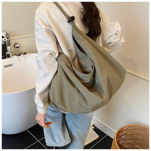 Détail du sac fourre-tout vert olive avec perles en bois et texture de tissu souple