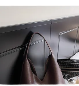 Detail of wide integrated handle on deep brown faux leather tote bag for work