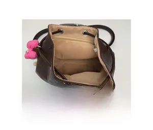 Deep brown textured backpack interior featuring a fabric lining and zipper pocket