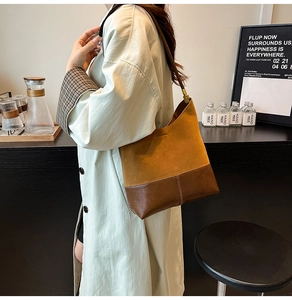 Détail du sac cabas en daim marron avec bandoulière contrastée et texture riche