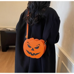 Detail of pumpkin crossbody bag with Jack-O-Lantern face on long black coat outfit