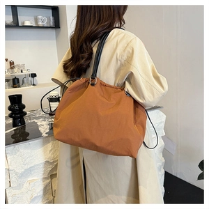 Back view of a caramel large tote bag with drawstring and thin black leather straps