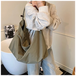Détail d'un cabas en nylon vert armée avec des nœuds tissés décoratifs et des perles en bois