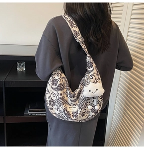 Detail der Hobo-Tasche mit schwarz-weißem Paisley-Muster und Wolken-Plüsch-Anhänger