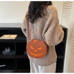 Detail of pumpkin crossbody bag featuring orange face stitching and slim leather strap