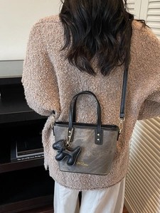 Retro grey matte bucket bag with a dog charm shown on the model for daily style