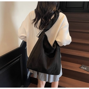 Detailed view of the wide shoulder strap on a large black minimalist canvas tote bag