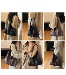 Detail view of large tote bag in black and coffee leather with natural texture and soft strap