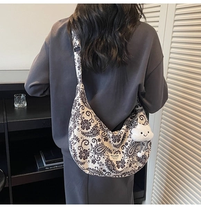 Detail der Paisley-Canvas-Tasche mit verstellbarem Riemen und Plüsch-Wolken-Anhänger