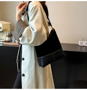 Détail du sac cabas noir montrant le contraste entre le daim mat et le cuir lisse