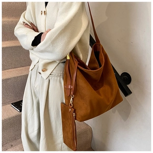 Detail of brown suede tote bag with matching mini pouch and elegant gold hardware