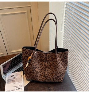 Détail du sac cabas en daim léopard avec breloque décorative en perles et bandoulières