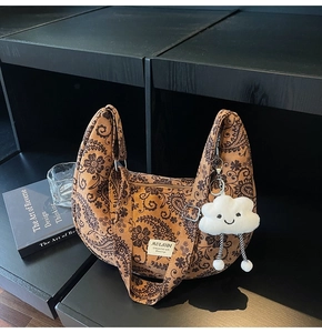 Detail der Retro-Paisley-Tasche mit weißem Wolkenanhänger und verstellbarem Riemen