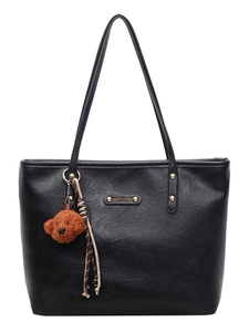 Black leather tote bag with teddy bear pendant and striped ribbon on white background