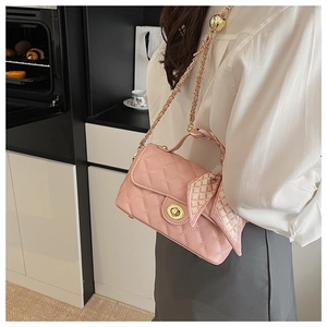 Détail du sac à bandoulière rose matelassé avec fermoir doré et détail de foulard