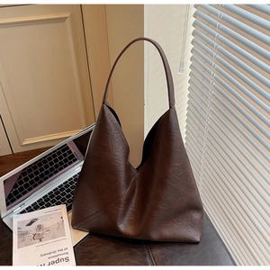Detailed view of the dark brown wrinkled leather texture on a spacious tote bag