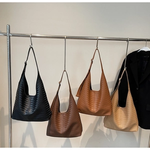 Sacs cabas tressés en quatre couleurs présentés sur un support métallique chic